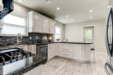 Wonderful view of the kitchen! High quality KraftMaid cabinets were installed in 2019, along with an intricate glass tile backsplash, and butterfly, black granite countertops! Extra long modern pulls, and a deep stainless apron sink and faucet, add to the sophisticated feel of this room. All the appliances are black stainless, you have to see this kitchen to truly appreciate it!