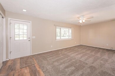 Carpeted foyer entrance with ceiling fan