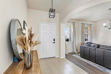 Welcoming entryway with a modern light fixture. Th