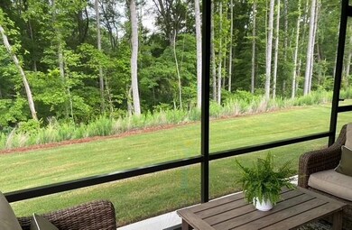 Sunroom / solarium featuring a view of trees