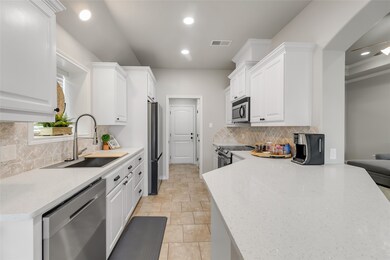 This modern kitchen features sleek white cabinetry