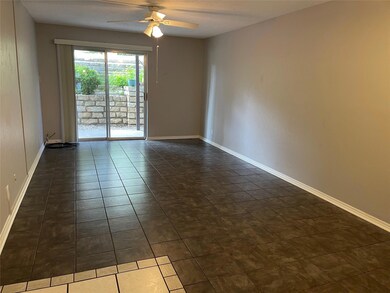 Unfurnished room featuring ceiling fan and dark t