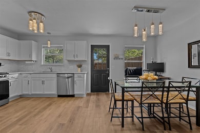 Kitchen featuring white cabinets, appliances with