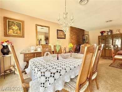 Dining area with a chandelier and carpet floors