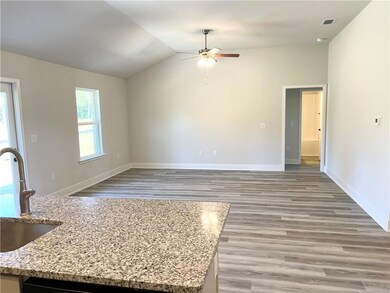 Unfurnished living room featuring vaulted ceiling, light wood-style flooring, and ceiling fan