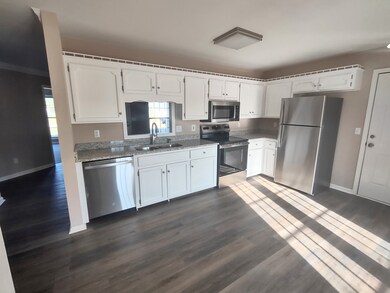 Kitchen has reworked cabinets, new granite countertops, and new stainless steel appliances, look at that beautiful laminate flooring as well.