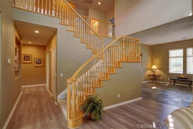Beautiful staircase.  Hallway leading to downstairs bedroom and bath on the left and laundry/garage on the right.
