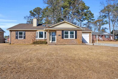 Ranch-style home featuring a garage and a front ya