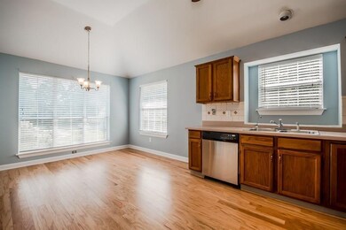 Kitchen featuring brown cabinets, a sink, dishwash