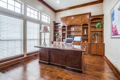 Large study has built in shelving and a small desk on the opposite wall.