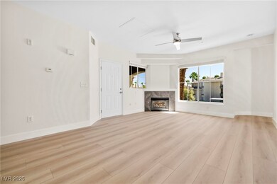 living room with light wood-style floors, a premium fireplace, and ceiling fan