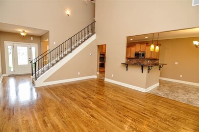 The great room opens up with soaring vaulted ceilings and hardwood floor.
