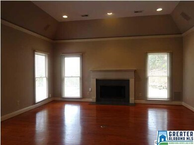 Living area with gleaming hardwoods and wood burni