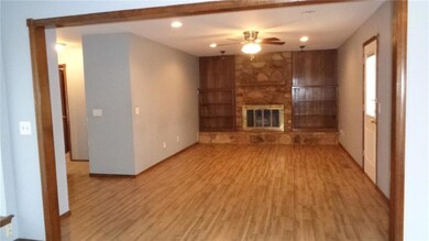 Laminate flooring, builtins and wood burning fireplace. Note door to backyard.