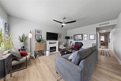 Living room featuring a ceiling fan, a fireplace,