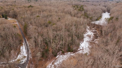 Birds eye view of property featuring a wooded view