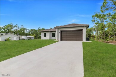 Prairie-style house featuring a front lawn, driveway, stucco siding, and a garage