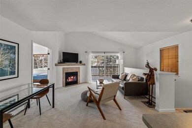 Carpeted living room with a tiled fireplace and va