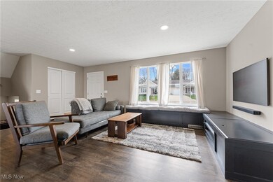 Living area featuring a textured ceiling, wood finished floors, and recessed lighting