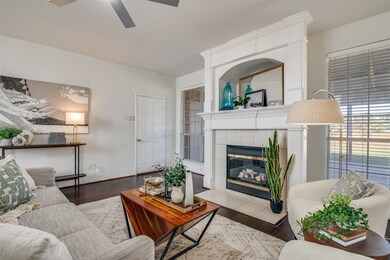 Living area featuring a fireplace, wood finished floors, and ceiling fan