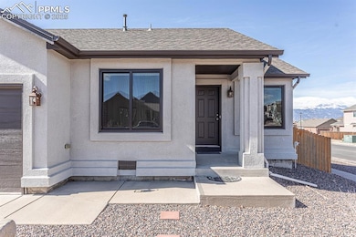 Property entrance with stucco siding, fence, and a
