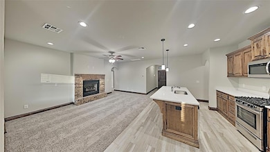 Kitchen featuring stainless steel appliances, arched walkways, a ceiling fan, recessed lighting, and open floor plan