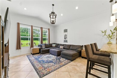 Living area with light tile patterned floors, lofted ceiling, crown molding, and recessed lighting