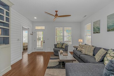 Living area featuring hardwood / wood-style flooring, a ceiling fan, recessed lighting, healthy amount of natural light, and baseboards