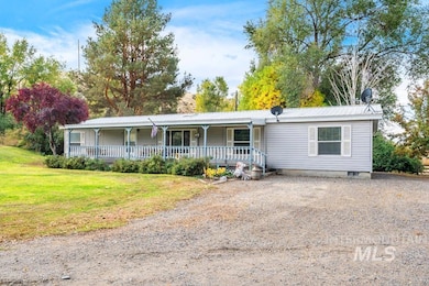 View of front of house with covered porch, a front lawn, and a metal roof