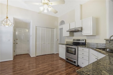 Large open kitchen with stone countertops and whit