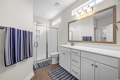 Full bathroom with vanity and tiled shower stall.