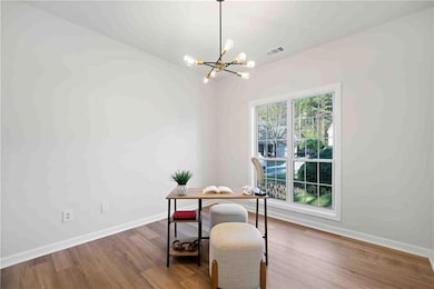 Office area with a chandelier, wood finished floors, and baseboards