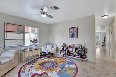 Sitting room with ceiling fan and light tile patte