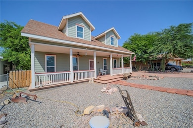 View of front of house with ceiling fan and covere