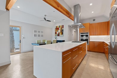 Kitchen featuring lofted ceiling, finished concre