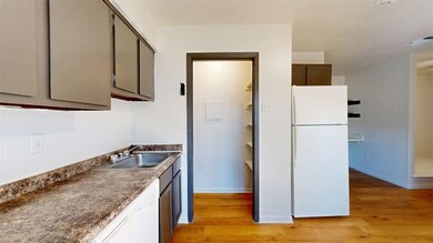 Kitchen with white appliances, light wood-style fl
