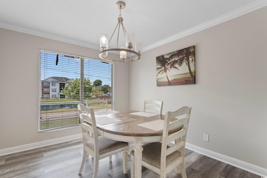 Dining area with a chandelier, baseboards, crown m