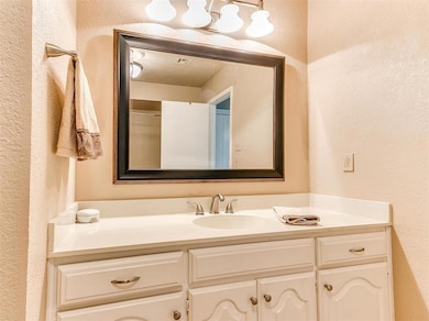 Bathroom with a textured wall and vanity