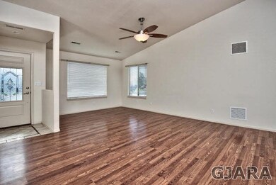 The spacious living room pairs hardwood flooring t