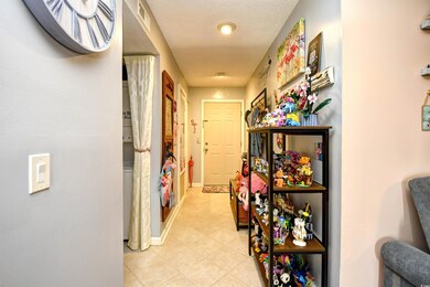 Corridor with light tile patterned flooring and baseboards