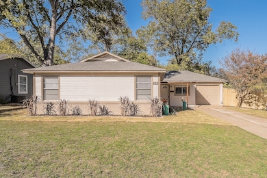 Ranch-style home with a front lawn, concrete driveway, roof with shingles, and a garage
