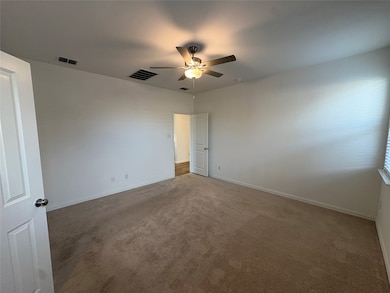 Carpeted spare room with baseboards and a ceiling fan