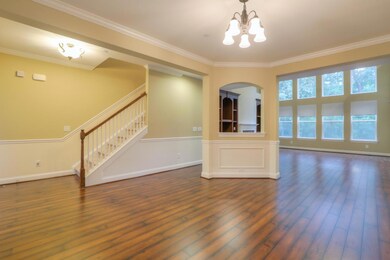 Built-in bookcases add dignity and symmetry. The fireplace anchors that wall with a two story ceiling. The room is filled with natural light. Beautiful.