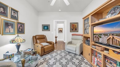 Sitting room with a ceiling fan and wood finished floors