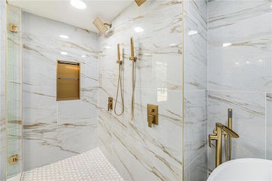 Full bathroom with a marble finish shower, a soaking tub, and recessed lighting