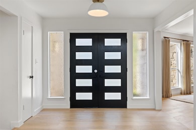 Foyer with wood-type flooring and baseboards
