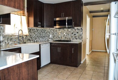 Kitchen with country sink, microwave, and double oven.