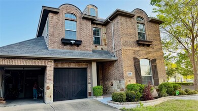 View of front facade with a garage, brick siding, and driveway