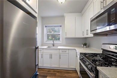 Kitchen featuring quartz counters & stainless steel appliances.