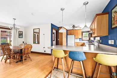 Kitchen featuring freestanding refrigerator, plenty of natural light, baseboards, and a chandelier